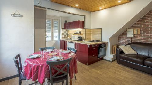 une cuisine avec une table et un chiffon rouge dans l'établissement Les Suites du Jardin - Eden - Option Payante Jacuzzi, à Chaumont