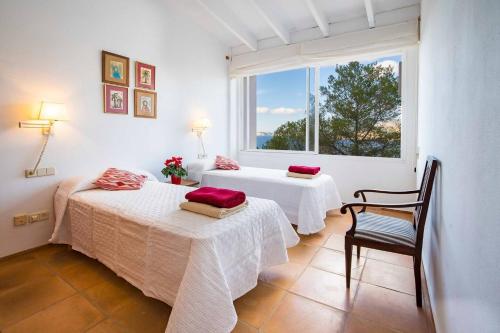 a bedroom with two beds with red pillows on them at Villa Vistas Dragonera by Mallorca Infinity in Andratx