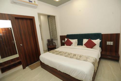 a bedroom with a large white bed with red pillows at Rajmoti hotel & Restro in Udaipur