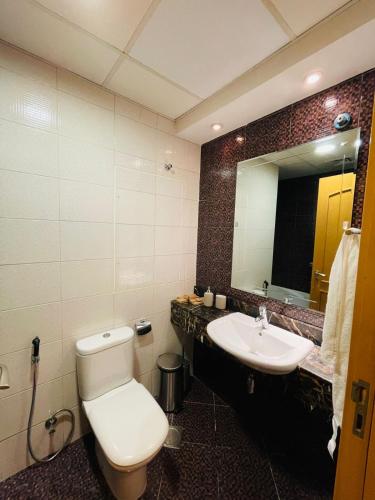a bathroom with a toilet and a sink and a mirror at Big Studio Apartment in Dubai Marina Walking to JBR Beach, Cruise and DMCC Metro in Dubai