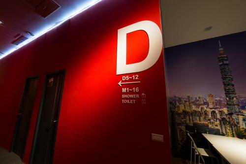 a red wall with the letter d on it at SleepBox Hostel in Taipei