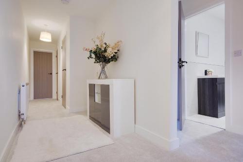 a hallway with a vase of flowers on a table at Columbia Road in Bournemouth
