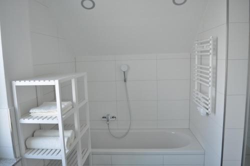 a white bathroom with a shower and a tub at B Home SLEEP & WORK in Burgrieden