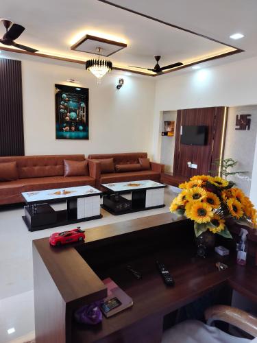 a living room with a couch and a table with flowers at Prem villas homestay in Tājganj