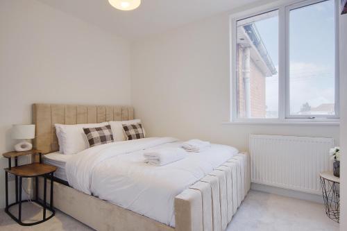a white bedroom with a large bed with white sheets at Columbia Road in Bournemouth