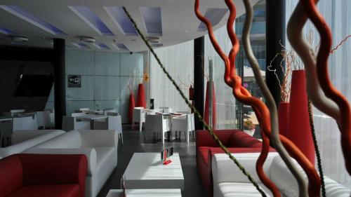 a room with red and white chairs and tables at Apolo Suites Rentalmar in Salou