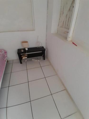 a room with a white floor and a piano at Studio confortable à Les Abymes, 12m², balcon agréable in Les Abymes