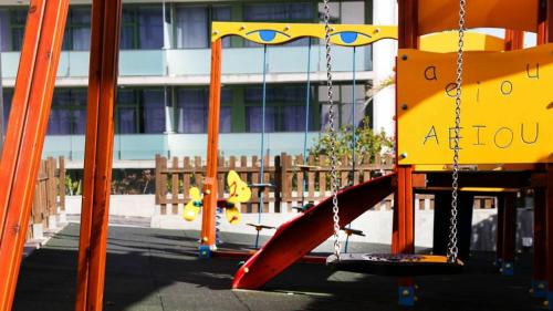 a swing set in a playground with a slide at Apolo Suites Rentalmar in Salou