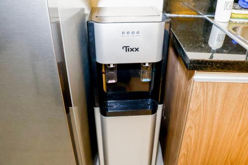 a trkk coffee machine sitting on top of a counter at Bayfront 1BR Condo in Pasay Manila with Wi-Fi, Netflix & Pool Access, Near NAIA Airport, Mall of Asia, OKADA, CCP & PICC in Manila