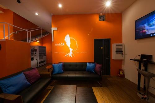 a living room with a couch and a tv at SleepBox Hostel in Taipei