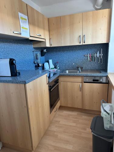 a kitchen with wooden cabinets and a sink at Appartement Alpenhof Wildschönau in Niederau