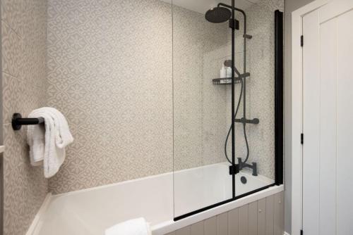 Un baño con ducha con puerta de cristal. en Honeysuckle Cottage, Kailzie, en Peebles