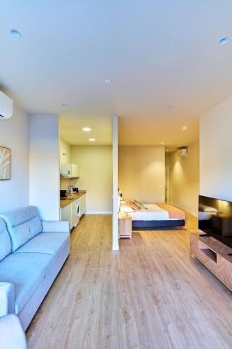 a living room with a couch and a bed at Apartamentos Delia by gaiarooms in León