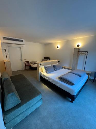 a bedroom with a large bed and a couch at Agriturismo B&B Caffè e Vino in Sondrio