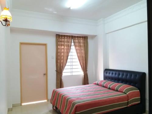 a bedroom with a bed and a window at Brinchang Cameron Highlands Homstay in Brinchang