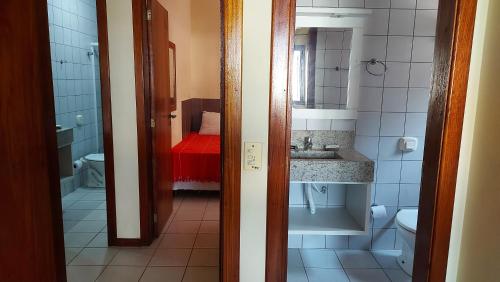 a bathroom with a sink and a toilet and a mirror at Praia Brava Apto 2 dorms Vista ao Mar in Florianópolis