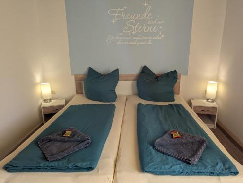 a bedroom with two beds with blue sheets and pillows at Ferienwohnung Nico in Stadtilm