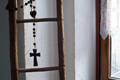 a wooden cross and a rosary hanging on a wall at La Vallée Hôtel &Spa in Lourtier
