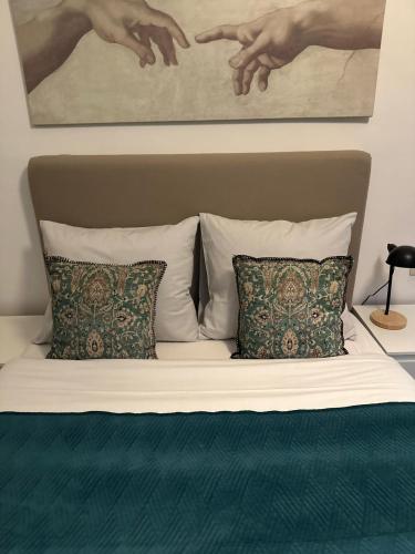 a bed with two pillows and a painting on the wall at Happy Home in Brussels