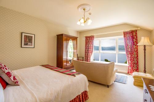 a bedroom with a bed and a chair and a window at Carrig Country House & Restaurant in Killorglin