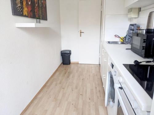 a kitchen with white counters and a wooden floor at Beautiful Apartment in Velbert in Velbert