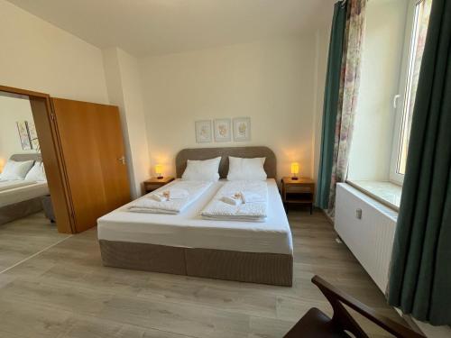 a bedroom with a large bed with two lamps at Sonnenschein-Apartment in Hermeskeil