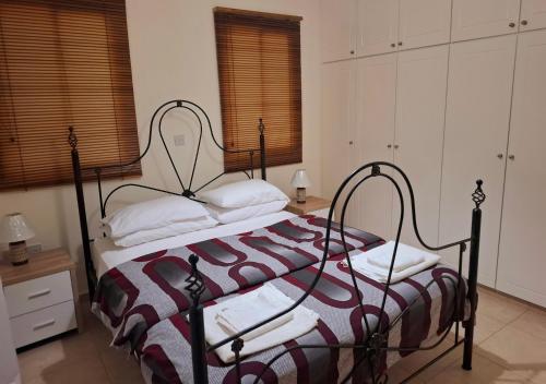 a bedroom with a bed with a striped bedspread at Sunset Green 01 in Paphos City