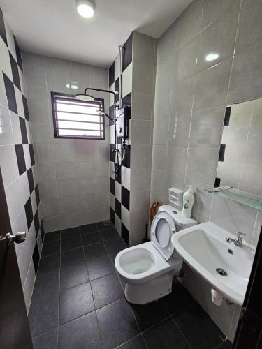 a bathroom with a toilet and a sink at Thea Homestay in Sepang