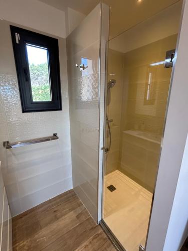 une douche avec une porte vitrée dans une salle de bain dans l'établissement Petit Paradis, à Roquefort-les-Pins