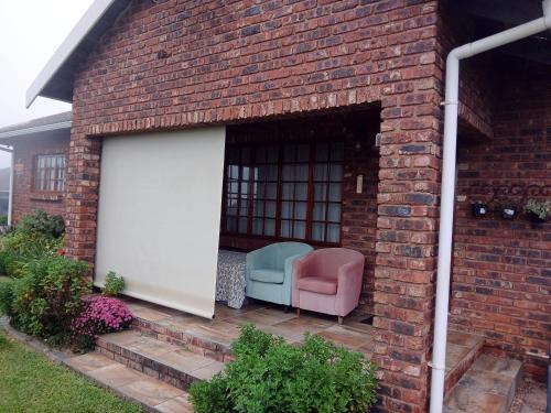 a building with a garage with a chair and a door at Hope at Mangaliso in Hilton