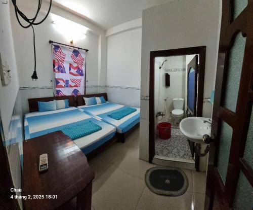 a bedroom with a bed and a sink and a mirror at Nhà nghỉ Kim Long Chùa Bà Châu Đốc Núi Sam in Chau Doc