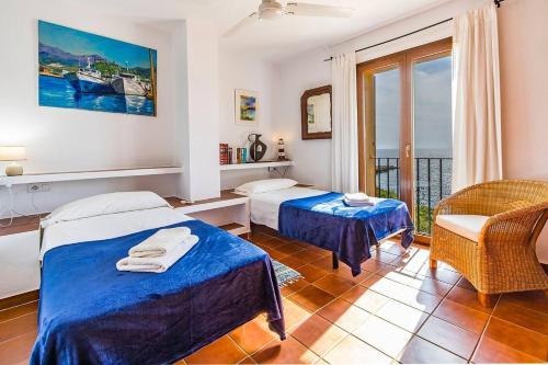 a hotel room with two beds and a balcony at Casita Marinera Sant Elm by Mallorca Infinity in Sant Elm