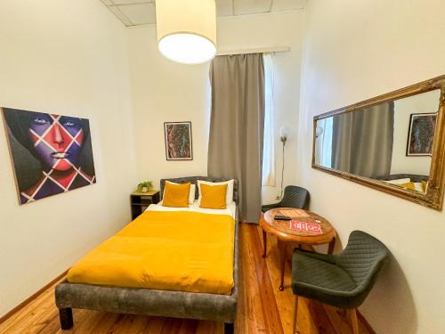 a bedroom with a bed and a table and a chair at The Only One Suites in Niš