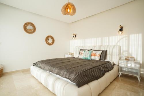 una camera da letto con un letto grande in una stanza bianca di Taghazout Serenity a Tamraght Ouzdar