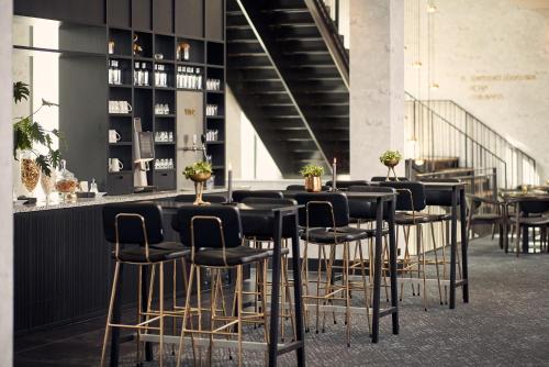 a group of stools in a room with a bar at Van der Valk Hotel Amsterdam - Amstel in Amsterdam