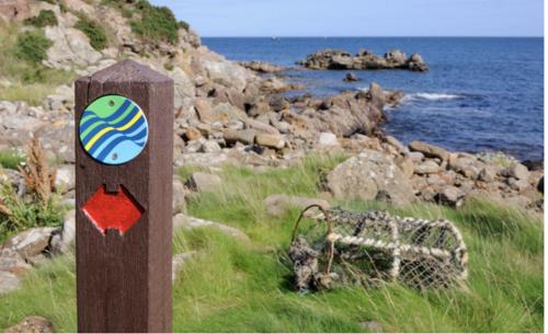 a wooden post with a sticker on it next to the ocean at The Upper Largo Hotel & Restaurant in Lundin Links