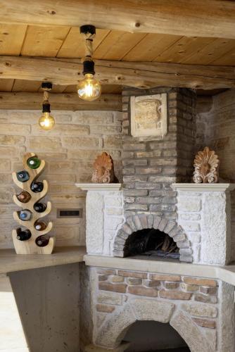 a stone fireplace in a room with wine bottles at Elegant Villa with Pool & Views in Áptera