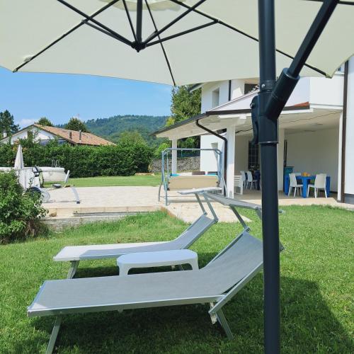 a couple of lounge chairs under an umbrella at TerrazzaPonente in Monte San Pietro