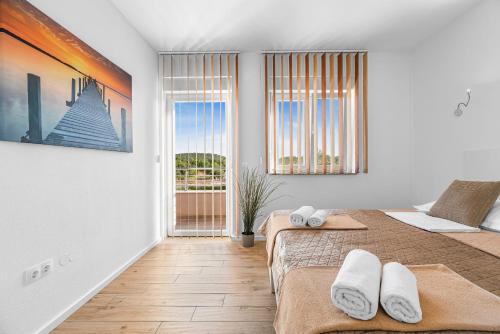 a bedroom with two beds and a large window at Villa Magdalena ZadarVillas in Polača