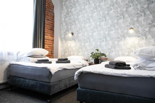 two beds sitting next to each other in a room at New Adler Bed & Breakfast in Łódź