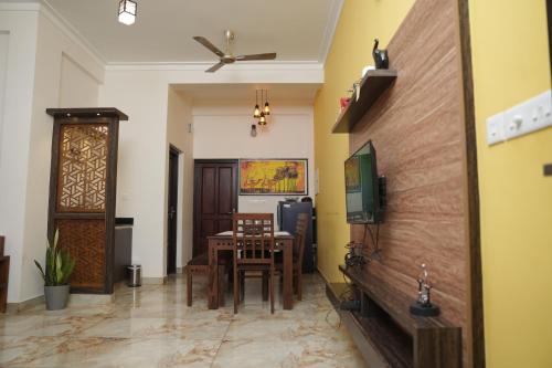 a dining room with a table and a ceiling fan at AVANTI CASTELLO in Guruvāyūr