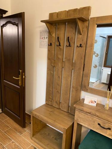 a wooden cabinet with a bench next to a door at Two Rivers Bran in Bran