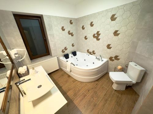 a bathroom with a tub and a toilet and a sink at Two Rivers Bran in Bran