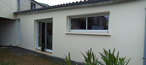 Maison blanche avec 2 fenêtres dans l'établissement Le Faubourg Gourdon, à Beaupréau