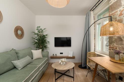 a living room with a green couch and a table at Τhe 1930s in Mytilini