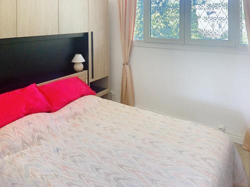 une chambre avec un grand lit avec des oreillers rouges dans l'établissement Superbe 2 pièces 344L Jol, à Cannes