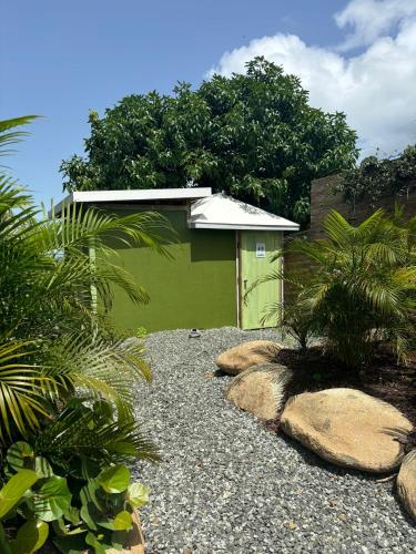 a green building with rocks in front of it at Aleli Cottages in Culebra