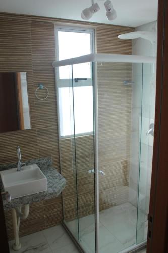 une salle de bain avec une douche en verre et un lavabo dans l'établissement Flat Makaranduba Centro Porto de Galinhas,dois quartos, à Porto de Galinhas