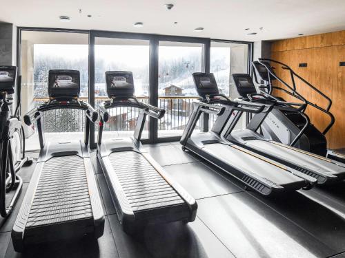 a gym with two treadmill machines and a window at Swissôtel Damian Jasna in Demanovska Dolina