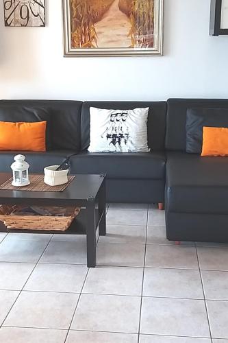 a living room with a black couch and a coffee table at CASA di SILVA tra MONTI e LAGHI PERLEDO REGOLEDO in Regoledo